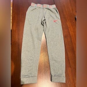 Nike youth sweat pants.  Gray with bright pink/coral letters and swoosh. Size YL